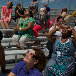 Faculty and guests view the eclipse from the stadium at Roy J Smith middle school. 