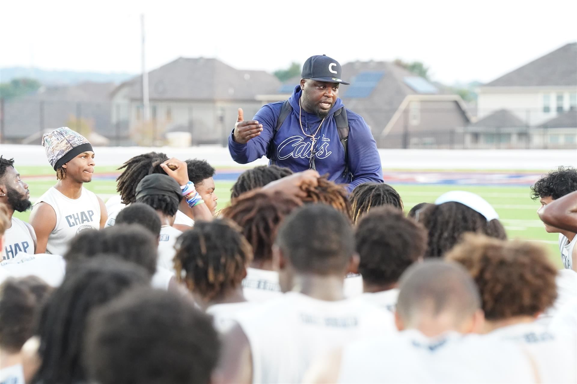 Coach talks to players in a huddle
