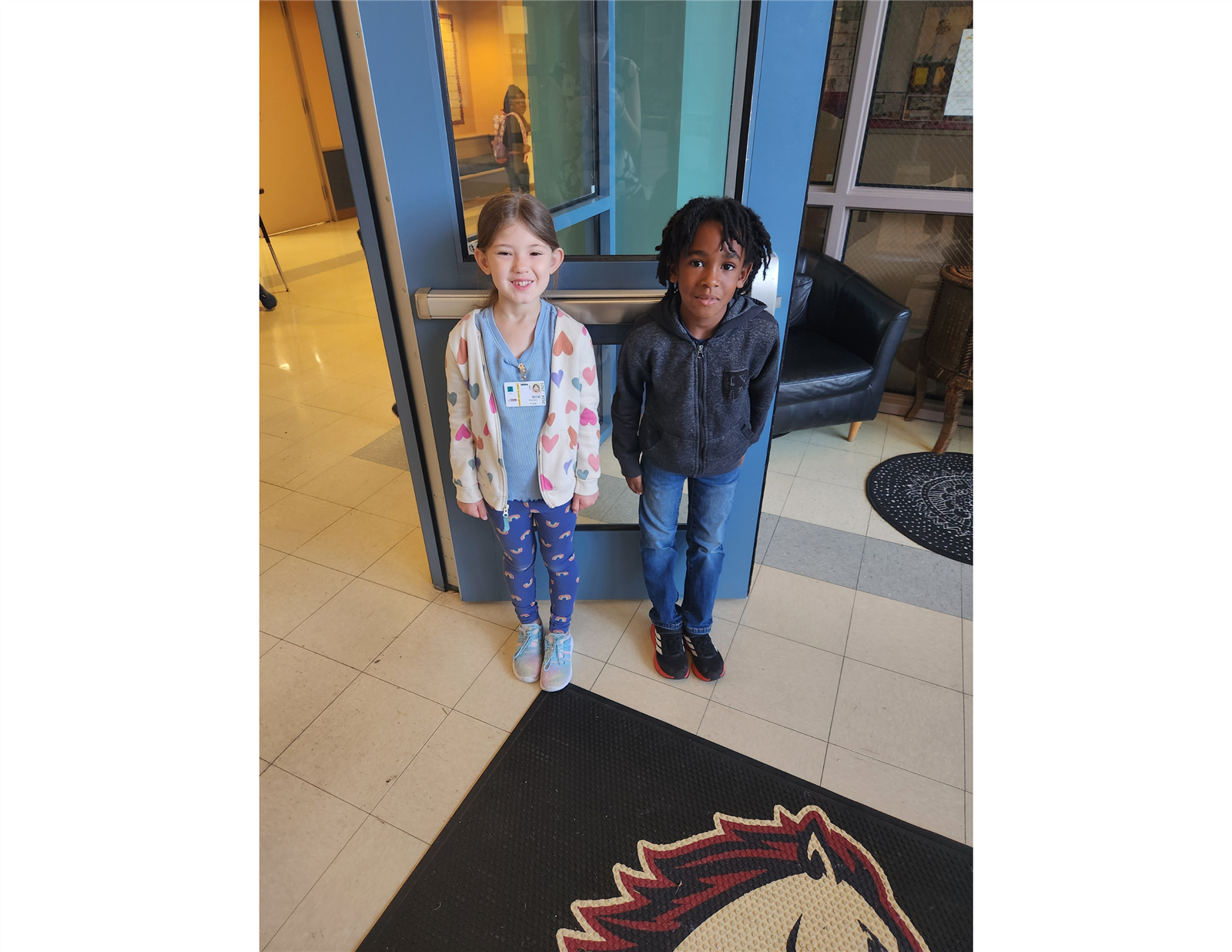 Two Maverick Ambassadors holding the door foor others entering the school building. Two Maverick Ambassadors holding the door foor others entering the school building.